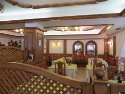 a restaurant with tables and chairs and a bar at Hotel Pordoi - Fam Furgler in Arabba