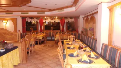 a dining room with yellow tables and chairs in it at Hotel Pordoi - Fam Furgler in Arabba