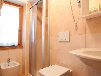 a bathroom with a shower and a toilet and a sink at Hotel Pordoi - Fam Furgler in Arabba