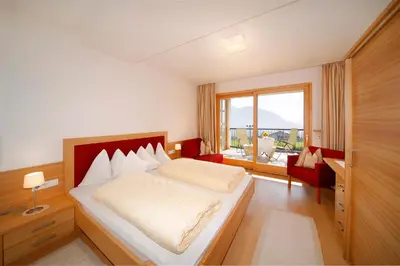 a bedroom with a bed and a large window at Haselgrund in Tirolo