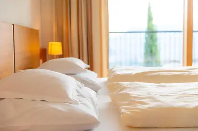 two beds in a hotel room with white pillows at Haselgrund in Tirolo
