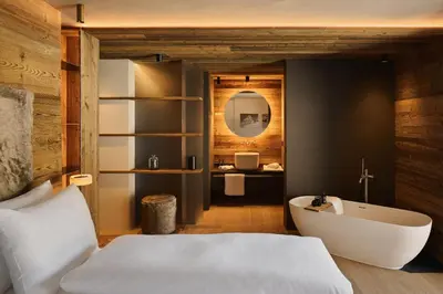 a bedroom with a white bed and a bath tub at Les Pares in Corvara in Badia
