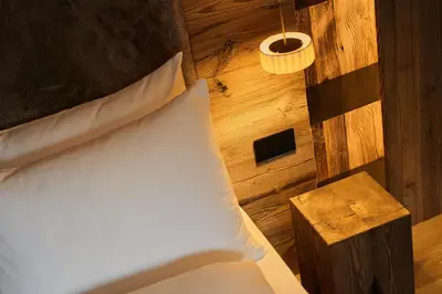 a bedroom with a bed and a wooden wall at Les Pares in Corvara in Badia