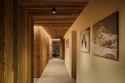 a hallway with wooden ceilings and a hallway with pictures on the walls at Les Pares in Corvara in Badia