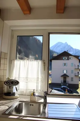 a kitchen sink and a window with a view of a house at Appartamento Ika in Canazei