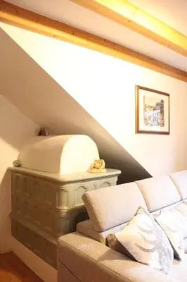 a living room with a couch in a attic at Appartamento Ika in Canazei