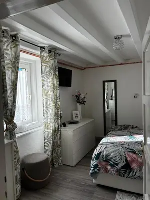 a bedroom with a bed and a desk and a window at Appartamento Ika in Canazei