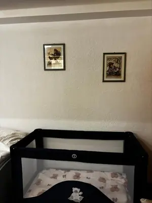 a bedroom with two pictures on the wall and a crib at Appartamento Ika in Canazei