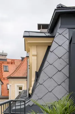 a house with a black roof and stairs at Steinach10 in Merano