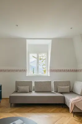 a living room with a couch and a window at Steinach10 in Merano