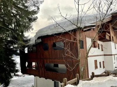 a kitchen with wooden cabinets and a table and chairs at Appartamento La Montanella in Cortina dʼAmpezzo