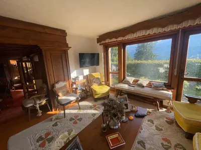 a living room with wooden floors and a chandelier at Appartamento La Montanella in Cortina dʼAmpezzo