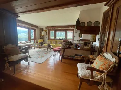 a house with wooden doors and a yard at Appartamento La Montanella in Cortina dʼAmpezzo