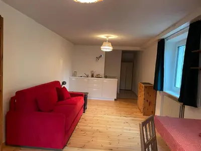 a living room with a red couch and a kitchen at Monoloclae-Prati di Solaiolo in Solaiolo