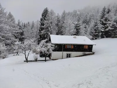 a house covered in snow in front of trees at Monoloclae-Prati di Solaiolo in Solaiolo