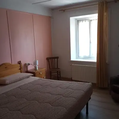 a bedroom with a bed and a window and a chair at Lili's house in Pera