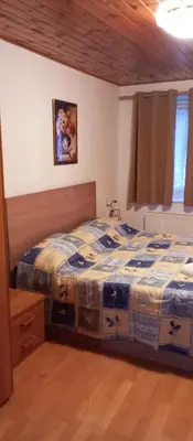 a bedroom with a bed with a blue and white comforter at Lili's house in Pera