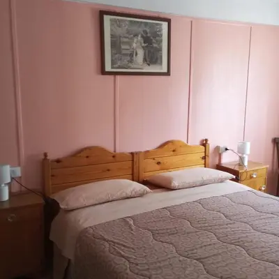 a bedroom with a large wooden bed with two pillows at Lili's house in Pera