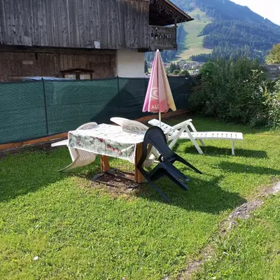 a table and a chair and an umbrella on the grass at Lili's house in Pera
