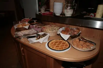 a table with many different types of bread and pies at Garni Eden in Canazei