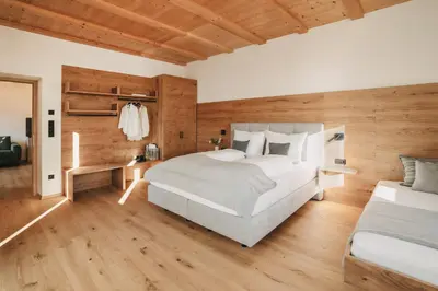 a bedroom with a large bed and wooden walls at Stein unter Lebenberg NEW 2026 in Cermes