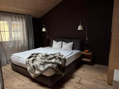 a bedroom with a bed with a blanket on it at La Maison 35 - Zentrales Wohnhaus in Bruneck in Brunico