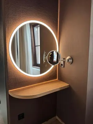 a bathroom with a round mirror on a door at La Maison 35 - Zentrales Wohnhaus in Bruneck in Brunico