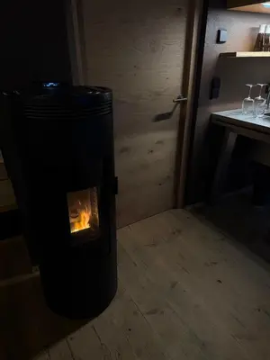 a fireplace with a fire in it in a room at La Maison 35 - Zentrales Wohnhaus in Bruneck in Brunico