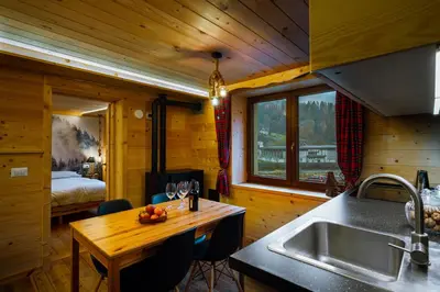 a kitchen with a sink and a table in a cabin at Dolomiti Urban Lodge - casa Marmolada in Cencenighe