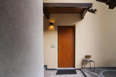 a wooden door in a building with a table at Dolomiti Urban Lodge - casa Marmolada in Cencenighe
