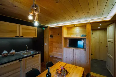 a kitchen with a wooden ceiling and a wooden table at Dolomiti Urban Lodge - casa Marmolada in Cencenighe
