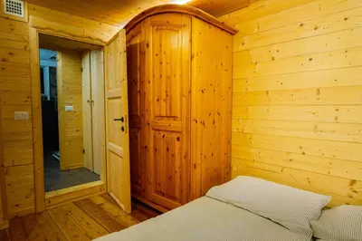 a bedroom with a bed in a wooden cabin at Dolomiti Urban Lodge - casa Marmolada in Cencenighe