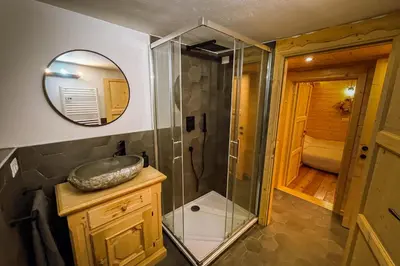 a bathroom with a shower and a sink and a mirror at Dolomiti Urban Lodge - casa Marmolada in Cencenighe