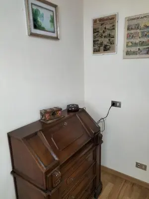 an old wooden dresser in a corner of a room at Appartamento l'angelo in Predazzo
