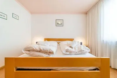 a bedroom with a bed with two pillows at Appartamento Bernardi in Caprile