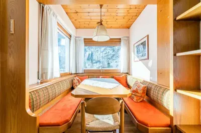 a dining room with a bench and a table at Appartamento Bernardi in Caprile