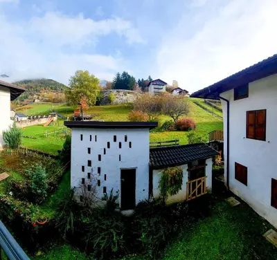 a building with green doors and a staircase at Casa Diletta in Prade