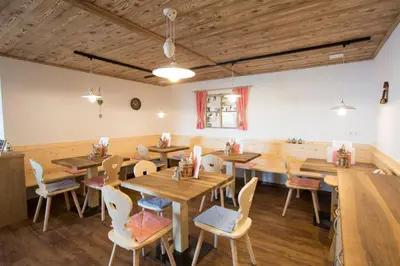 a dining room with wooden tables and chairs at Unterthurnerhof in Rifiano