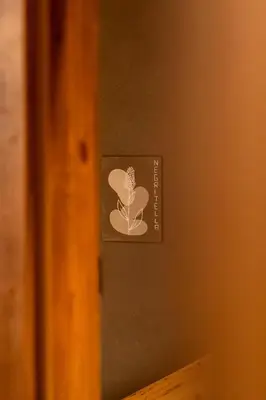 a sign on a wall with a flower on it at Guest House Fleim in Panchia