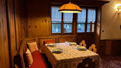 a dining room with a table and a window at Mansarda Ca Geranei in San Vito di Cadore