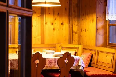 a dining room with a table and a table and chairs at Mansarda Ca Geranei in San Vito di Cadore