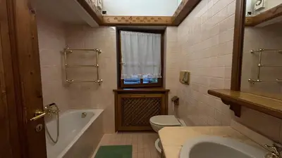 a bathroom with a tub and a toilet and a sink at Mansarda Ca Geranei in San Vito di Cadore