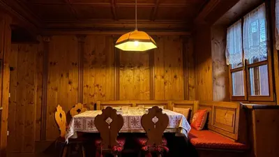 a dining room with a table and chairs and a lamp at Mansarda Ca Geranei in San Vito di Cadore