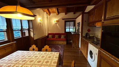 a kitchen with a table and a counter top at Mansarda Ca Geranei in San Vito di Cadore
