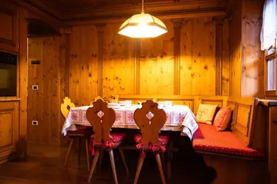 a dining room with a table and two chairs at Mansarda Ca Geranei in San Vito di Cadore