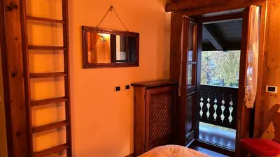 an orange room with a mirror and a window at Mansarda Ca Geranei in San Vito di Cadore