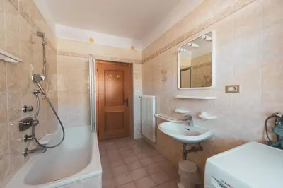 a kitchen with wooden cabinets and a table and a sink at Casa Pettena in Pozza di Fassa