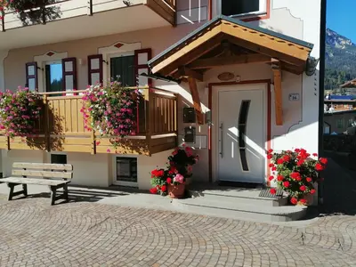 a building with wooden balconies in front of a mountain at Casa Pettena in Pozza di Fassa