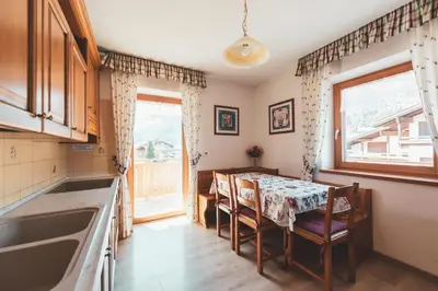 a small kitchen with a table and a window at Casa Pettena in Pozza di Fassa