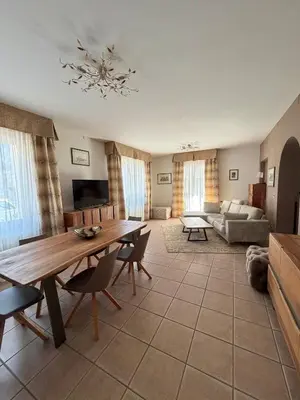 a living room with a table and a couch at Villa Serena - appartamento a Fiera di Primiero in Tonadico